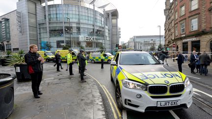 Des voitures de police devant le centre commercial où&nbsp;cinq personnes ont été poignardées à Manchester (Royaume-Uni), le 11 octobre 2019.&nbsp; (PETER POWELL / REUTERS)