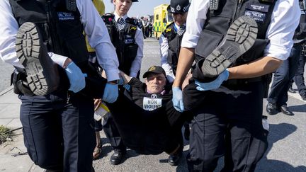 Un militant écologiste arrêté par la police alors qu'il bloquait le pont de Waterloo à Londres, le 20 avril 2019.&nbsp; (NIKLAS HALLE'N / AFP)