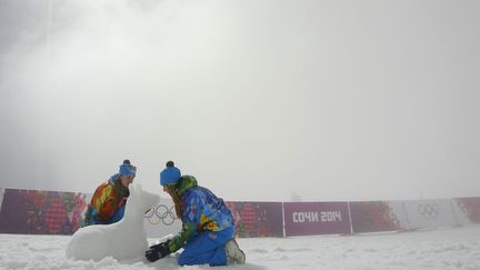 Des &eacute;quipiers font un bonhomme de neige en attendant le d&eacute;but de l'&eacute;preuve de "mass start" lors des Jeux olympiques de Sotchi (Russie), le 16 f&eacute;vrier 2014. (SERGEI KARPUKHIN / REUTERS)