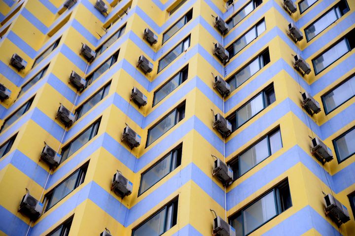 Des climatiseurs sur la façade d'un immeuble résidentiel de Shenyang, en Chine, le 8 juillet 2018.&nbsp; (ZHANG WENKUI / IMAGINECHINA / AFP)