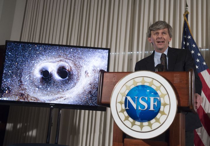 David Reitz, directeur du LIGO, montre la collision de deux trous noirs qui a provoqué les premières ondes gravitationnelles jamais enregistrées, lors d'une conférence de presse à Washington (Etats-Unis), le 11 février 2016. (SAUL LOEB / AFP)