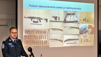 Un policier finlandaise présente les armes saisies lors de l'arrestation de cinq hommes soupçonnés de préparer un attentat d'ultra-droite, le 3 décembre 2021 à Pori (Finlande). (JUHA SINISALO / LEHTIKUVA / AFP)