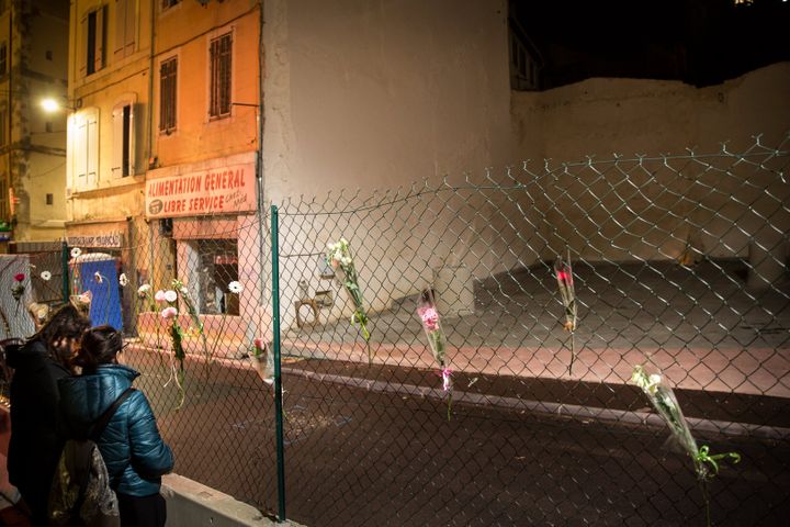 Des habitants se recueillent et accrochent des fleurs sur les lieux des effondrements d'immeuble, le 5 novembre 2019, un an après le drame de la rue d'Aubagne, à Marseille. (ANTHONY MICALLEF / HAYTHAM / REA)