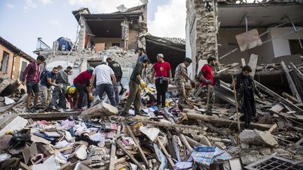 Des secouristes recherchent des survivants dans les décombres d'Amatrice, dans le centre de l'Italie frappé par un puissant séisme, le 24 août 2016. De magnitude 6, le tremblement de terre a provoqué la mort de 296 personnes. (AGF EDITORIAL / SIPA)