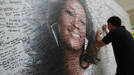 Un fan &eacute;crit un message sur un mur d'hommages destin&eacute;s &agrave; la chanteuse Whitney Houston, Quezon (Philippines), le 16 f&eacute;vrier 2012. (MAXPPP)