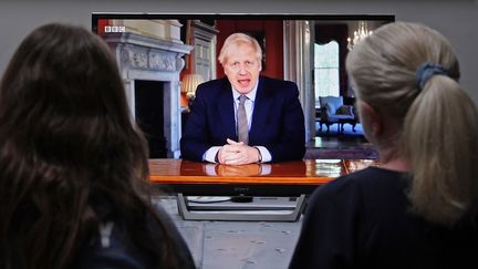 Une famille britannique regarde l'allocution du Premier ministre britannique Boris Johnson, à Londres, le 10 mai 2020. (ADRIAN DENNIS / AFP)