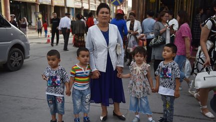 Une femme Ouïghoure et ses enfants à&nbsp;Kashgar, dans la région chinoise du&nbsp;Xinjiang, le 4 juin 2019. (GREG BAKER / AFP)