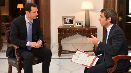 Le pr&eacute;sident syrien Bachar Al-Assad (gauche) est interrog&eacute; par David Pujadas, pr&eacute;sentateur du journal de 20 heures de France 2, &agrave; Damas, la capitale syrienne, le 19 avril 2015. ( SANA / AFP)