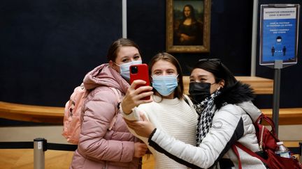 Des adolescentes devant "La Joconde" au musée du Louvre à Paris,&nbsp;le 14 octobre 2020. (LUDOVIC MARIN / AFP)