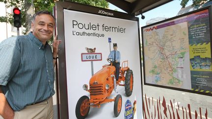 Yves de la Fouchardi&egrave;re, directeur g&eacute;n&eacute;ral des fermiers de Lou&eacute; pose devant la nouvelle affiche pour la campagne de publicit&eacute; des poulets de Lou&eacute;. (OLIVIER BLIN / MAXPPP)