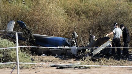 Des enquêteurs inspectent la carcasse d'un des deux hélicoptères impliqués dans l'accident, le 12 mars 2015 à Villa castelli (Argentine). (JUAN MABROMATA / AFP)