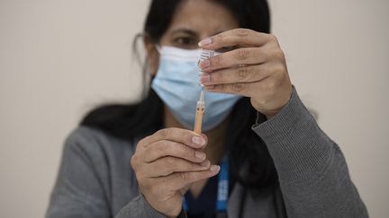 Une soignante manipule le vaccin AstraZeneca avant de l'administrer à un patient, à Nottingham, au Royaume-Uni, mardi 6 avril 2021.&nbsp; (OLI SCARFF / AFP)