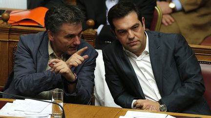 Le Premier ministre grec, Alexis Tsipras (&agrave; droite), et son ministre des Finances, Euclide Tsakalotos (&agrave; gauche), discutent lors d'une session au Parlement, le 25 juillet 2015 &agrave; Ath&egrave;nes.&nbsp; (ALKIS KONSTANTINIDIS / REUTERS)