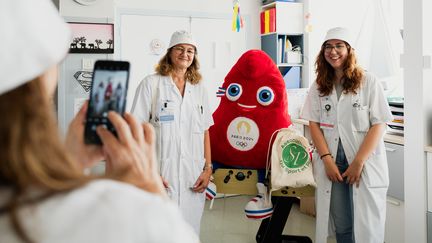 Des soignantes de l'hôpital Antoine-Béclère de Clamart (Hauts-de-Seine) se prennent en photo avec une mascotte des Jeux olympiques de Paris, le 7 août 2024. (PAULINE GAUER / FRANCEINFO)