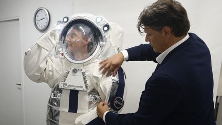 Rodrigo Basilicati-Cardin ajuste la combinaison LUNA de l'astronaute allemand Matthias Maurer, lors de la présentation du prototype au salon de mode Cardin à Paris, le 9 septembre 2024. (GEOFFROY VAN DER HASSELT / AFP)