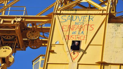 Serge Charnay, le p&egrave;re d'un enfant retranch&eacute; en haut d'une grue &agrave; Nantes, vient de tagguer l'engin, le 17 f&eacute;vrier 2013.&nbsp; (FRANK PERRY / AFP)