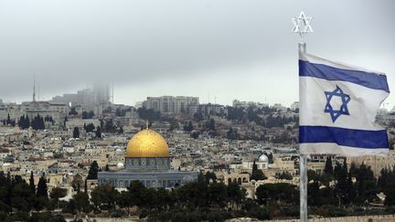 Un drapeau israélien flotte devant la ville de Jérusalem et le dôme du Rocher, le 6 décembre 2017. (MAHMOUD IBRAHIM / AFP)