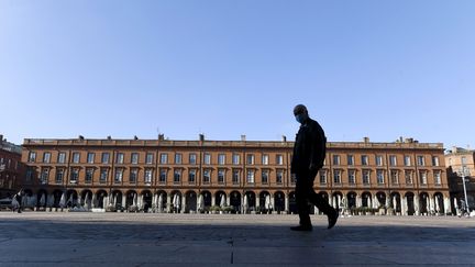 Un homme marche sur la place du Capitole à Toulouse, le 1er novembre 2020. (XAVIER DE FENOYL / MAXPPP)