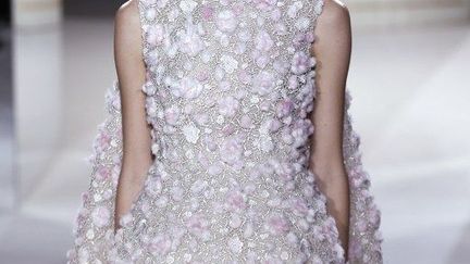 Chez Giambattista Valli, des robes du soir essentiellement, à motifs ou broderies florales et animales. Pas de fourrure pour autant ou très peu, plutôt du velours découpé pour imiter une peau de crocodile plaquée sur un organza blanc. Les fleurs elles sont soit brodées en fils métalliques argent sur un satin rose thé, soit "plantées" sur toute la robe.
	 
 (F.Guillot /AFP)