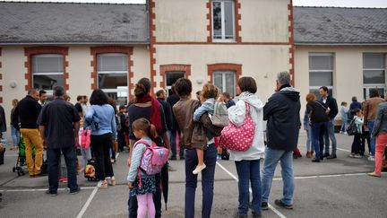 Des parents déposent leurs enfants à l'école, en septembre 2017. (Illustration).&nbsp; (LOIC VENANCE / AFP)