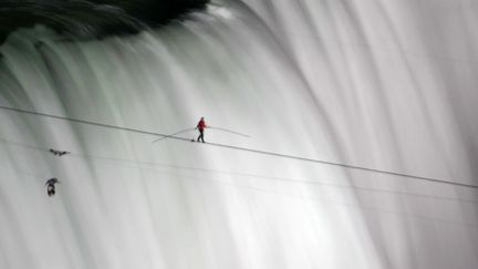 Le funambule Nik Wallenda traverse la fronti&egrave;re entre les Etats-Unis et le Canada&nbsp;devant les chutes du Niagara, le 15 juin 2012. (MARK BLINCH / REUTERS)