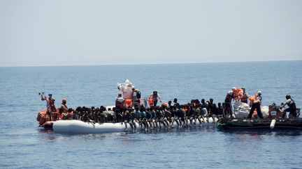 Des membres des ONG Médecins sans frontières et SOS Méditerranée viennent en aide à des migrants dans la mer Méditerranée, le 27 juin 2017. (LENA KLIMKEIT / AFP)