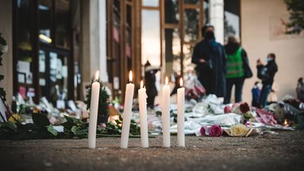 Des bougies déposées en hommage à Samuel Paty devant le collège du Bois d'Aulne, à&nbsp;Conflans-Sainte-Honorine (Yvelines), le 17 octobre 2020. (SAMUEL BOIVIN / NURPHOTO / AFP)