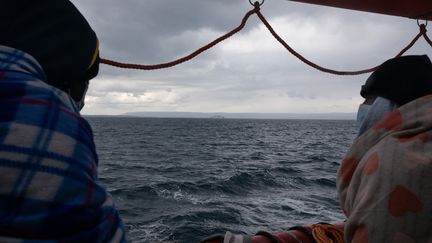 Deux migrants regardent la mer sur le bateau Ocean Viking, affreté par l ONG SOS Mediterranee, le 23 mars 2021 (JEREMIE LUSSEAU / HANS LUCAS / AFP)