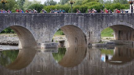 Le peloton du Tour de France 2021 traverse un pont à Chateauroux (Indre), ville d'arrivée de la 6e étape, le 1er juillet 2021. Photo d'illustration. (THOMAS SAMSON / AFP)