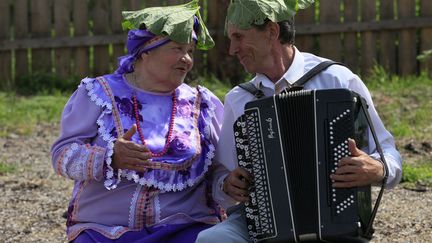 Des musiciens folkloriques russes se prot&egrave;gent du soleil avec des feuilles de bardane &agrave; Ust-Kem (Russie), le 15 juin 2013. (ILYA NAYMUSHIN / REUTERS)