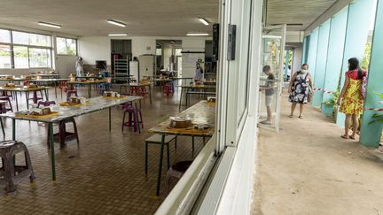 Une écolière arrive à la cantine, le 18 mai 2020, à Papeete (Polynésie française). (SULIANE FAVENNEC / AFP)