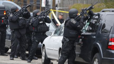 Des hommes de la SWAT, la brigade d'intervention d'&eacute;lite am&eacute;ricaine, encerclent une maison &agrave; Watertown (Etats-Unis), le 19 avril 2013. (BRIAN SNYDER / REUTERS)