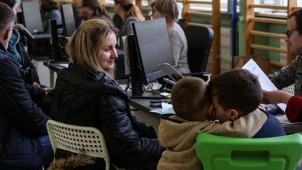 Des réfugiés ukrainiens s'enregistrent dans un bureau d'immigration en Pologne, le 5 avril 2022. (VALERIA MONGELLI / HANS LUCAS via AFP)