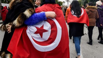 Des Tunisiennes défilent avec le drapeau national, lors d'un rassemblement sur l'avenue Habib Bourguiba à Tunis, le 14 janvier 2017, qui marque le 6e anniversaire de la révolution 2011. (FETHI BELAID / AFP)