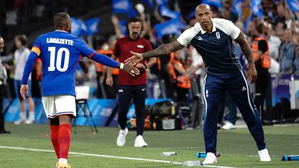 Alexandre Lacazette et son entraîneur Thierry Henry se tapent dans la main lors de France-Etats-Unis lors du tournoi olympique de football, le 24 juillet 2024, à Marseille. (NORBERT SCANELLA / AFP)