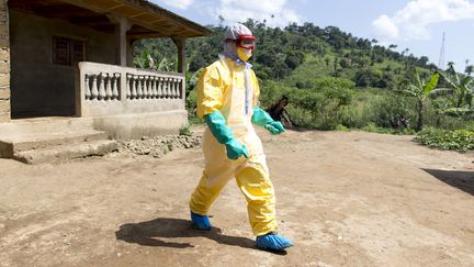 Un soignant quitte la maison d'une victime du virus Ebola &agrave; Macenta (Guin&eacute;e), le 21 novembre 2014. (KENZO TRIBOUILLARD / AFP)