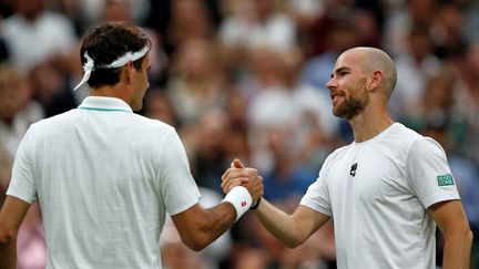 Roger Federer et Adrian Mannarino, à l'issue de leur match à Wimbledon, le 29 juin 2021. (ADRIAN DENNIS / AFP)