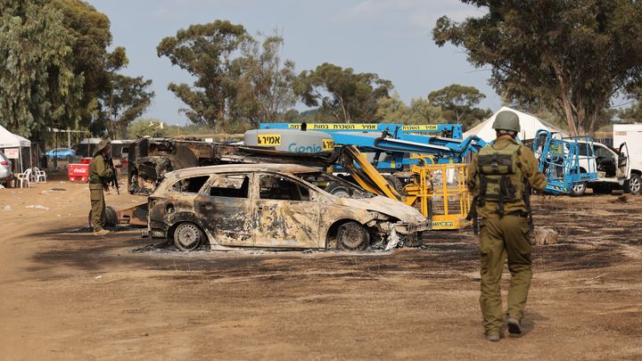 Des soldats inspectent des voitures incendiées après l'attaque du Hamas contre un festival de musique techno à Réïm (Israël), le 10 octobre 2023. (JACK GUEZ / AFP)