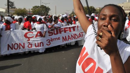 Une manifestante d&eacute;file avec 300 autres femmes &agrave; Dakar (S&eacute;n&eacute;gal), le 24 f&eacute;vrier 2012, pour protester contre la candidature d'Abdoulaye Wade &agrave; la pr&eacute;sidentielle. (ISSOUF SANOGO / AFP)