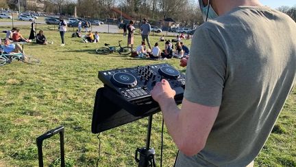 Un DJ mixe dans&nbsp;un parc public à Lille (Nord), mardi 30 mars 2021. (ANTOINE BAREGE / RADIO FRANCE)