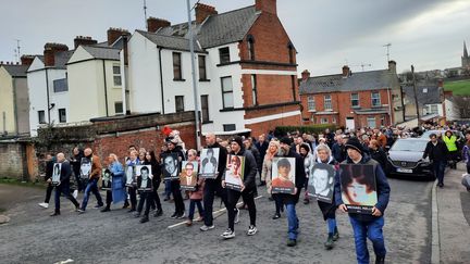 Les portraits des 13 victimes du "Bloody Sunday" portés en tête de cortège de la marche du souvenir à Derry (Irlande du Nord), le 30 janvier 2022. (RICHARD PLACE / RADIO FRANCE)