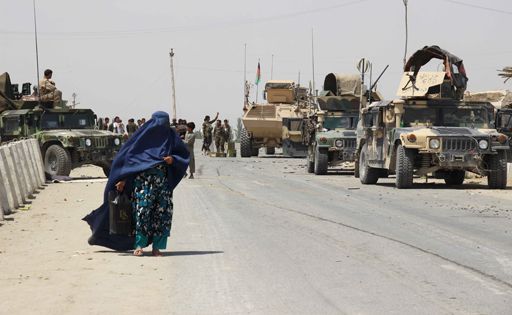 Une femme passe près de véhicules de l'armée afghane dans la province de Kunduz le 24 juin 2015. (Reuters - Stringer)