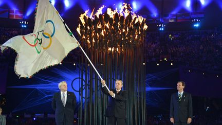 Le président du CIO Jacques Rogge, entouré du maire de Londres, Boris Johnson (à gauche), et du maire de Rio de Janeiro, Eduardo Paes. Ce passage de témoin a été effectué lors de la cérémonie de clôture des JO de Londres, le 12 août 2012. (JEFF J MITCHELL / POOL)