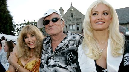 Le fondateur de "Playboy" pose entouré de son ex Barbi Benton (à gauche) et de sa compagne Holly Madison, devant son manoir à Beverly Hills en 2005. (ROBERT GALBRAITH / REUTERS)