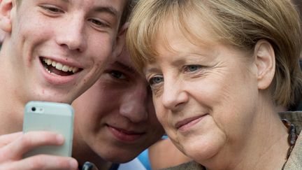 Angela Merkel pose pour un selfie en septembre 2014 (BORIS ROESSLER / DPA)