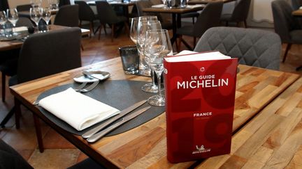 Le guide Michelin sur une table dans un restaurant de Saint-Mont (Gers), le 13 mai 2019. (SEBASTIEN LAPEYRERE / HANS LUCAS / AFP)