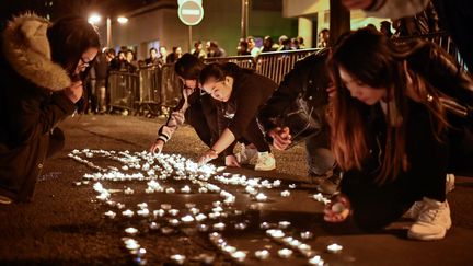 Des manifestants posent des bougies, dans le 19e arrondissement de Paris, après la mort d'un Chinois. (CHEN YICHEN / XINHUA / AFP)