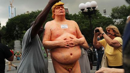 En difficulté dans les sondages, Donald Trump, candidat du Parti républicain à la présidentielle américaine, s'est retrouvé caricaturé dans les rues de plusieurs villes américaines. Une statue peu avantageuse le montrant nu a été notamment installée sur Union Square, lieu traditionnel de détente et de rencontres des New-Yorkais. La statue a ensuite été retirée par l'administration: «L'installation d'une structure ou oeuvre d'art non autorisée dans la ville est illégale».

Cette opération a été revendiquée par un collectif anarchiste Indecline, basé en Californie, qui a diffusé une vidéo montrant la fabrication de cinq statues identiques du candidat républicain.  (SPENCER PLATT / GETTY IMAGES NORTH AMERICA / AFP - Août 2016)