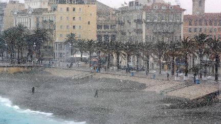 Quelques courageux s'aventurent sur la Promenade des Anglais à Nice (Alpes-Maritimes) alors qu'il neige abondamment, le 26 février 2018.&nbsp; (VALERY HACHE / AFP)