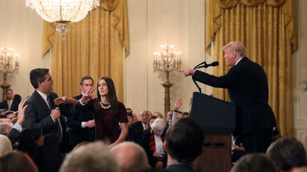 Une stagiaire de la Maison Blanche tente de prendre le micro à Jim Acosta, journaliste de la chaîne CNN, lors d'une conférence de presse de Donald Trump, le 7 novembre 2018 à Washington.&nbsp; (JONATHAN ERNST / REUTERS)